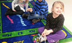 Three, Smiling, Young Children Sitting on Carpet