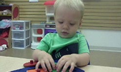 Young Boy Playing With Shapes Puzzle