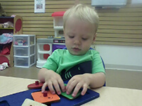 Young Boy Playing With Shapes Puzzle