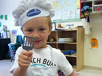 Young Boy Wearing a Chef's Cap and Spatula