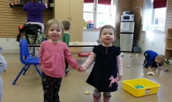 Two Young Girls Holding Hands and Smiling