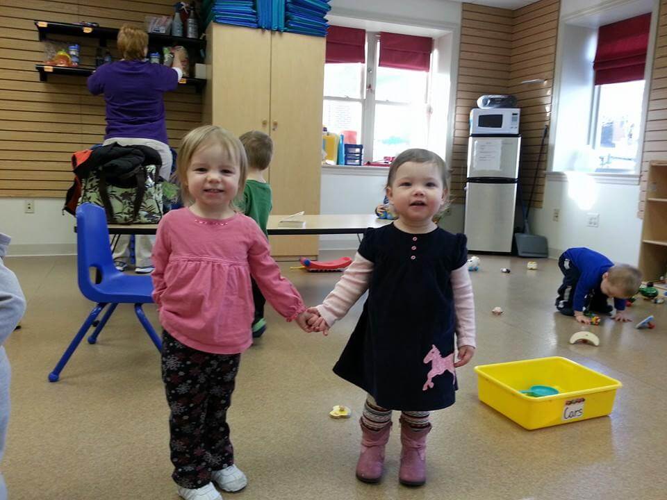 Two Young Girls Holding Hands and Smiling
