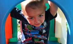 Young Boy Inside Outdoor Colorful Playhouse