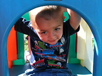 Young Boy Inside Outdoor Colorful Playhouse