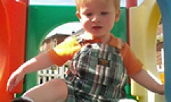 Young Boy Playing in Outdoor Colorful Playhouse
