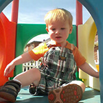 Young Boy Playing in Outdoor Colorful Playhouse